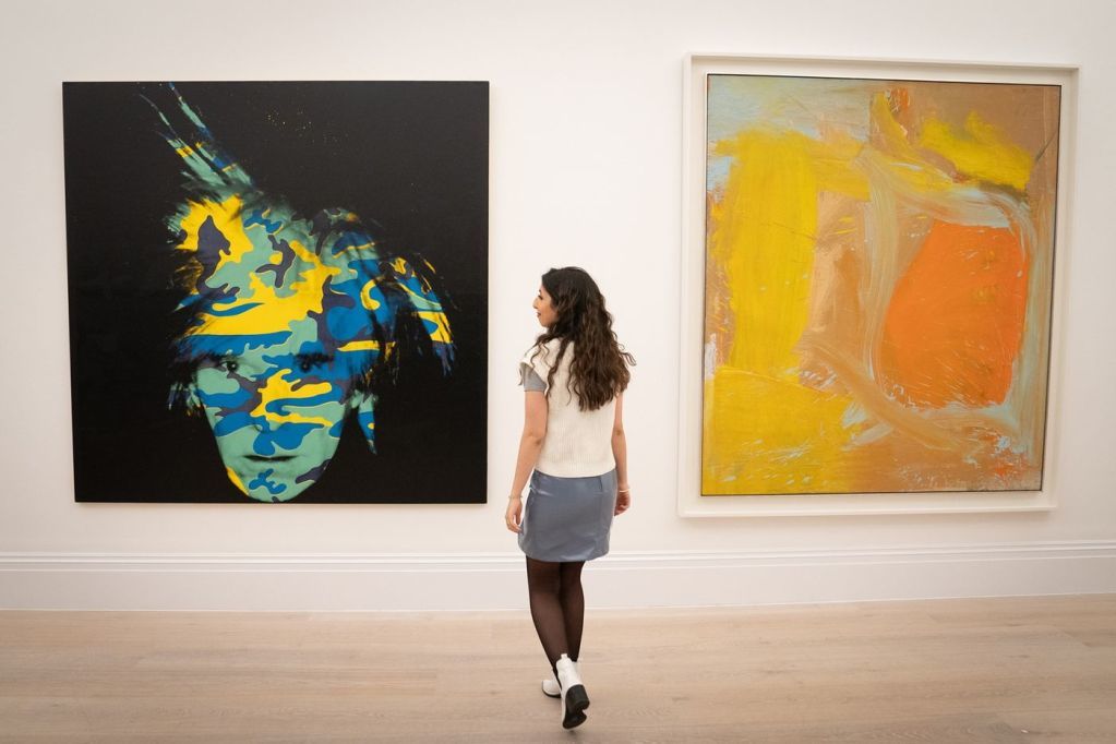 ニューヨークのオークションに出品される前にロンドンのサザビーズで展示されているアンディ・ウォーホルの≪Self-Portrait≫（左）とウィレム・デ・クーニングの≪Untitled≫（右