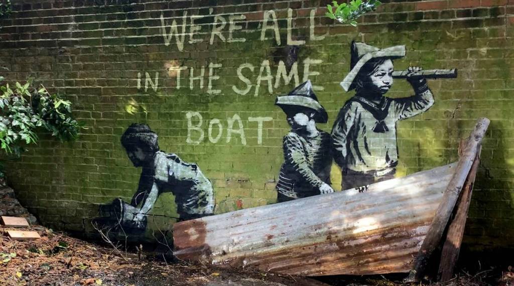手前の廃材を利用したバンクシーの壁画《We’re all in the same boat》(2021)