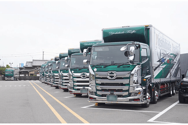 駐車場に並ぶ株式会社吉秀トラフィックのトラック