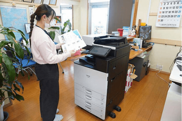 ホームページを自動でPDFにした会社案内のパンフレットを印刷する様子