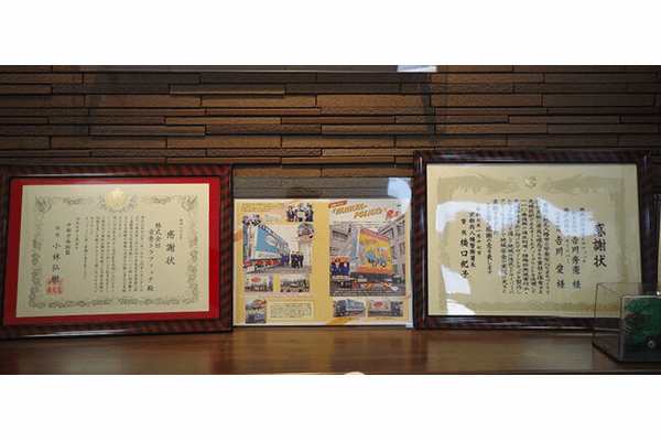 (左)警察署や自衛隊から贈られた感謝状、(右)八幡警察署と連携して行ったデザイントラックの表彰状