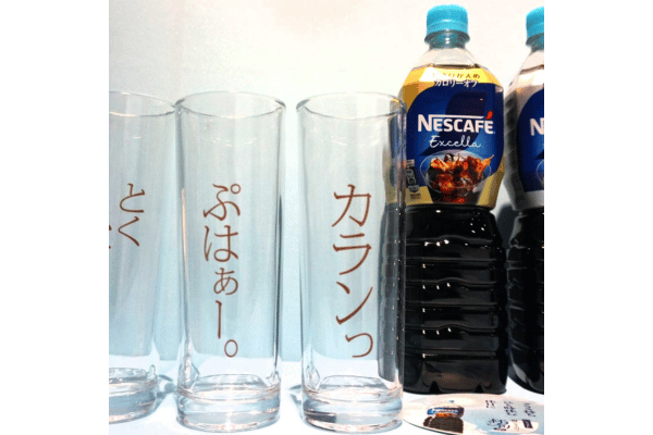 擬音語のフレーズがデザインされたグラスでアイスコーヒーが提供される