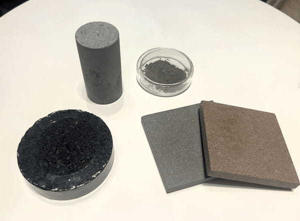 CO2吸収材を配合したコンクリートや床タイルなど。右上は吸収材、CO2を食べる自販機には箱に入ったCO2吸収材2㎏が２つ入っている。